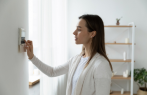 a woman is using thermostaer to control the temperature