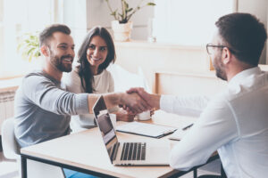 two people shaking hands at a table