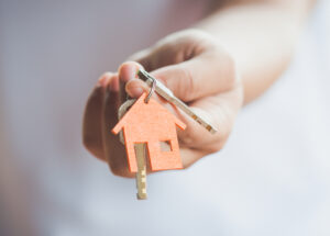 A person holding a key, symbolising access to a new home.