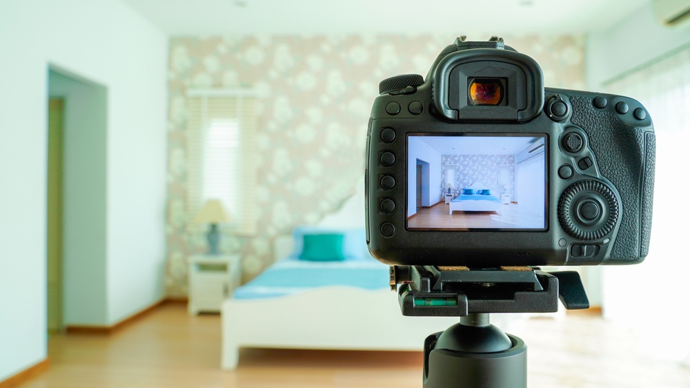 Camera on a tripod positioned in a well-decorated bedroom.